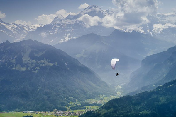 Homme en parachute au vol dans les Alpes.
