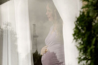 Femme enceinte regardant par la fenêtre.